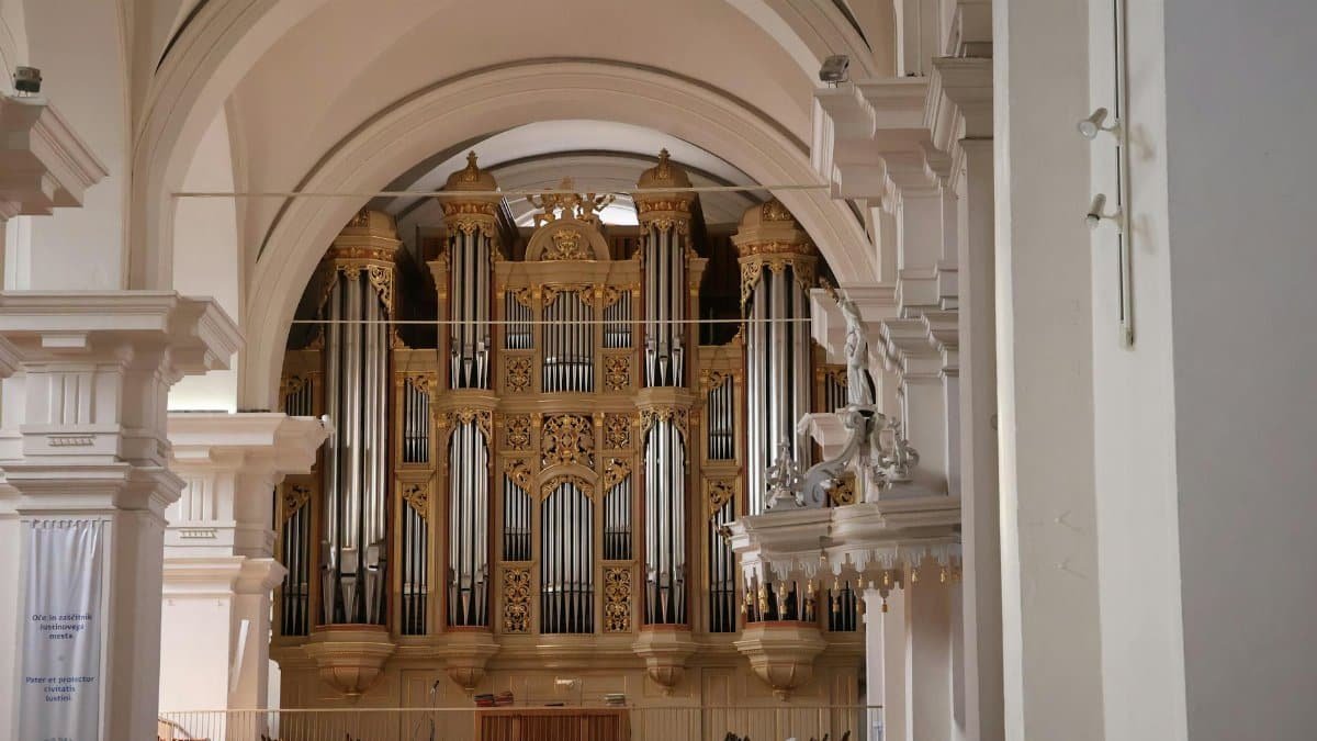 A majestic pipe organ inside a historic cathedral, showcasing elaborate architectural details.
