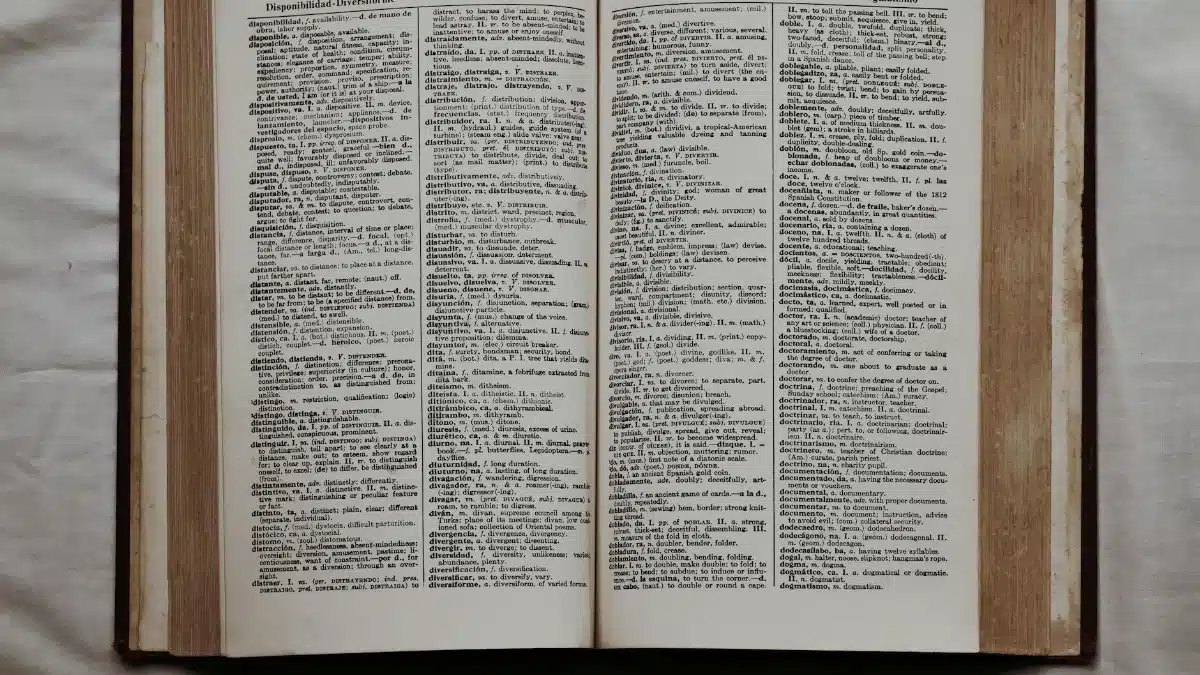 Close-up of an open dictionary showing English and Spanish translations, flat lay view.