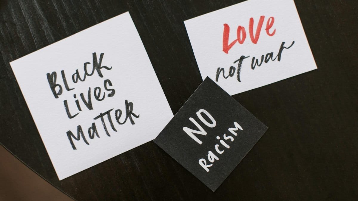 Collection of handwritten signs promoting equality and peace: Black Lives Matter, No Racism, Love Not War.