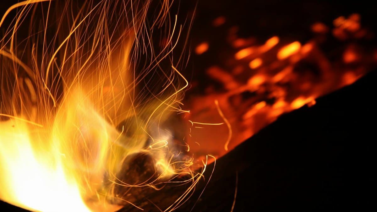 Long exposure shot of dynamic flames and sparks creating a warm atmosphere at night.