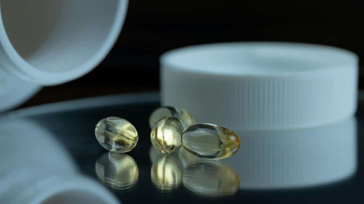 Focused image of gel capsules with a white bottle cap, emphasizing health and supplements.
