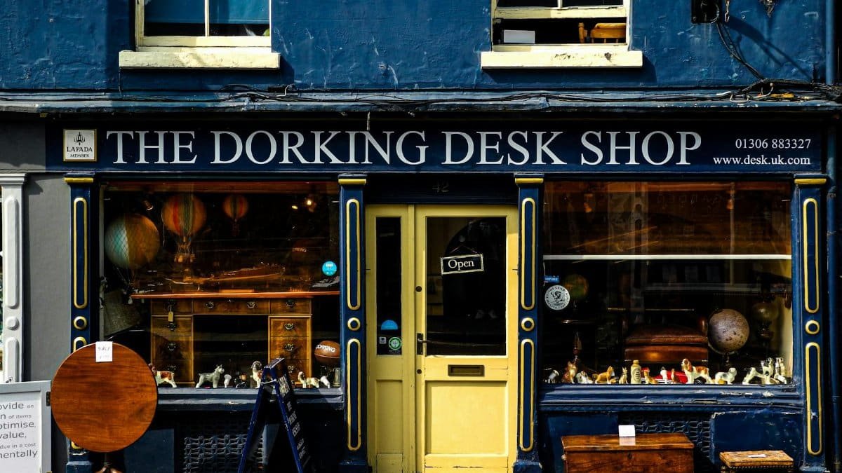 Exterior of The Dorking Desk Shop with vintage furniture and window display in a historic UK street.