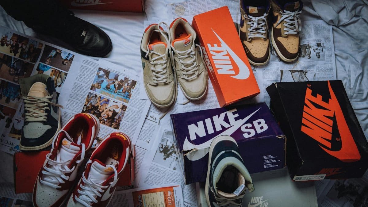 A variety of Nike sneakers displayed on newspapers with branded shoeboxes.