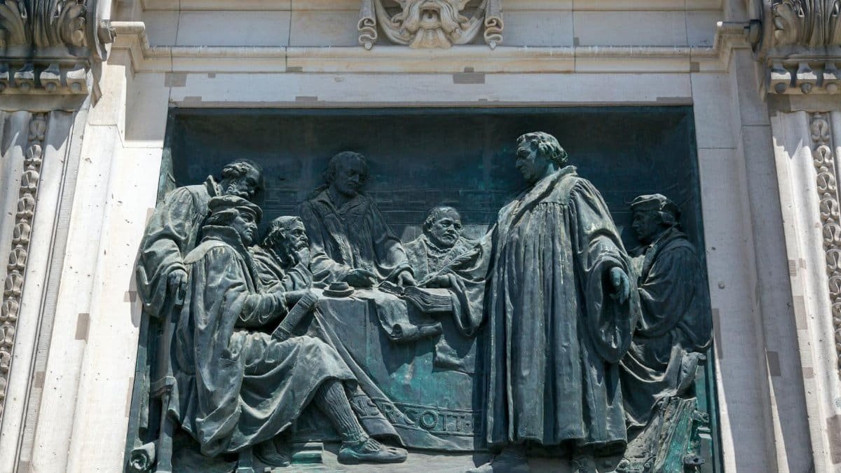 Detailed bronze bas-relief depicting historical figures in scholarly discussion.