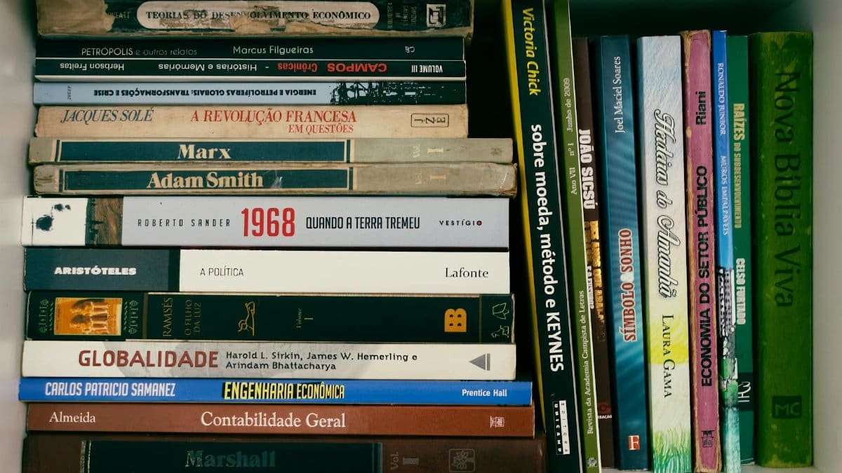 A neatly arranged bookshelf featuring books on economics, politics, and literature in Portuguese.