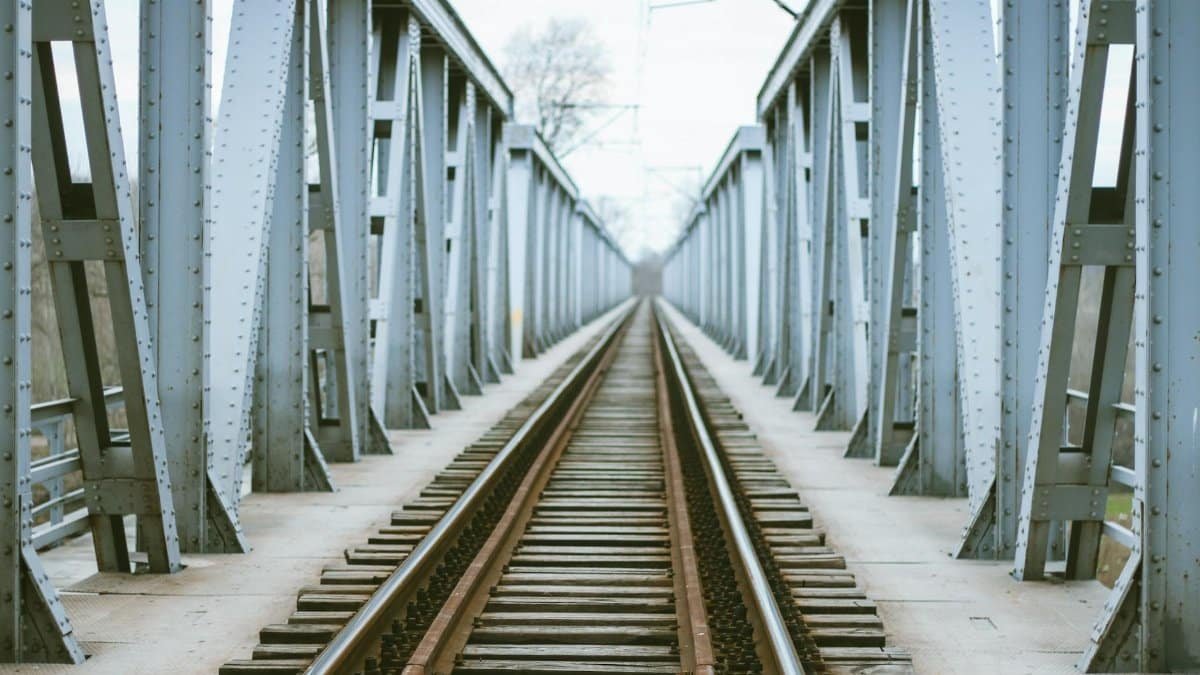 A historical railway bridge showcasing symmetrical iron structures and tracks.