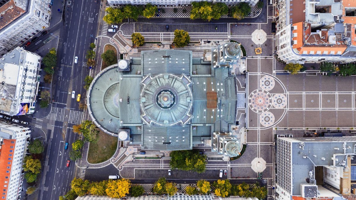 Drone shot showcasing St. Stephen's Basilica in Budapest, surrounded by city streets and architecture.