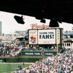 Crowd enjoying a baseball game at Wrigley Field, Chicago's iconic stadium, on a sunny day.