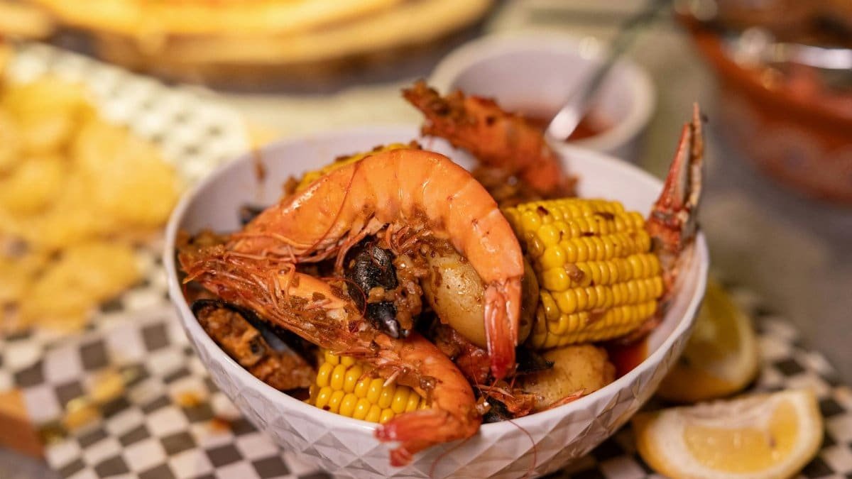 A vibrant seafood boil with shrimp, corn, and potatoes in a bowl, perfect for feast lovers.