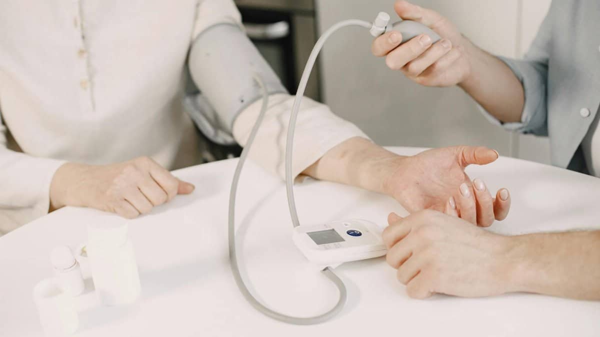 Close-up of blood pressure measurement at home highlighting healthcare equipment.