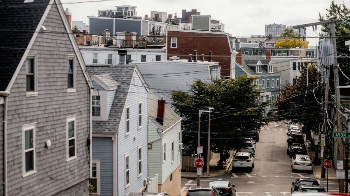 A scenic view of a residential neighborhood street with classic architecture and parked cars.