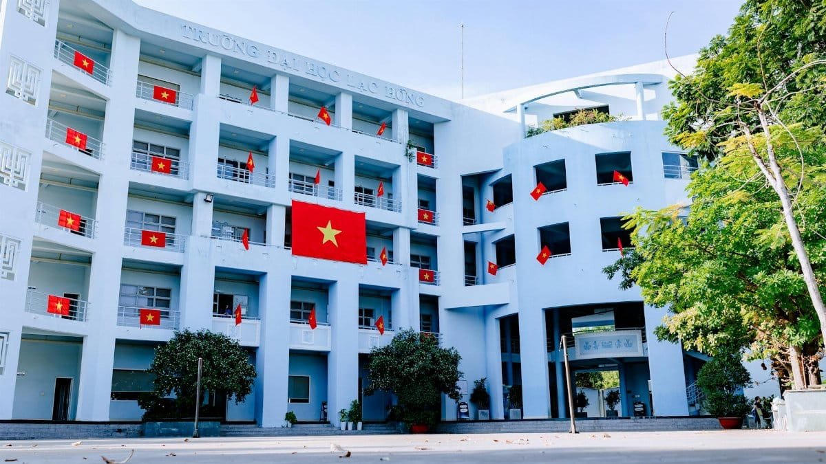 University building with Vietnamese flags, showcasing national pride on a sunny day.