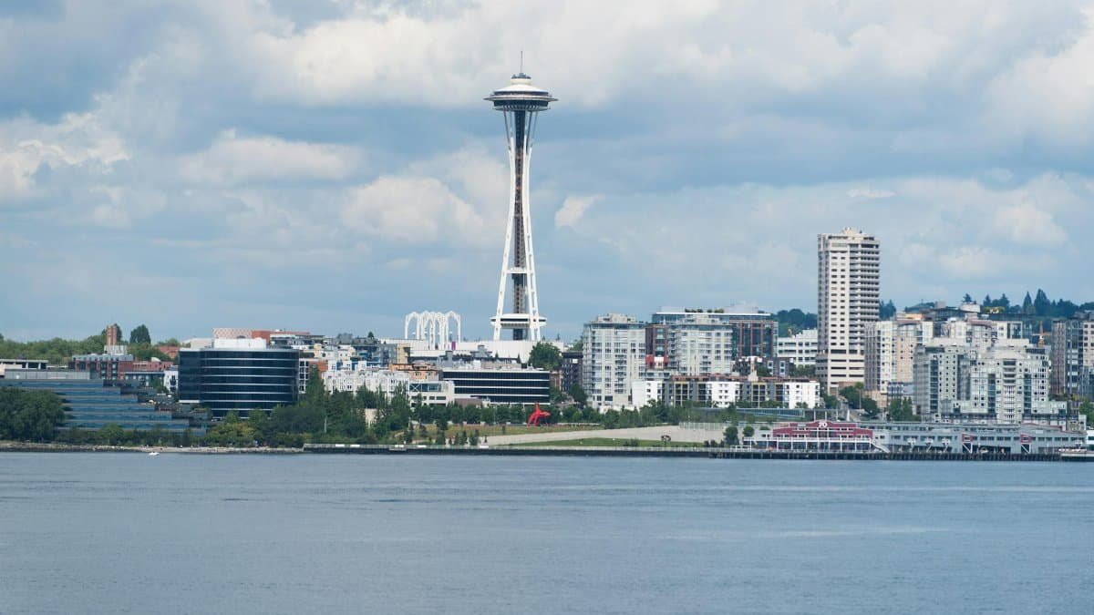 A scenic view of the Seattle skyline featuring the iconic Space Needle against a cloudy sky.
