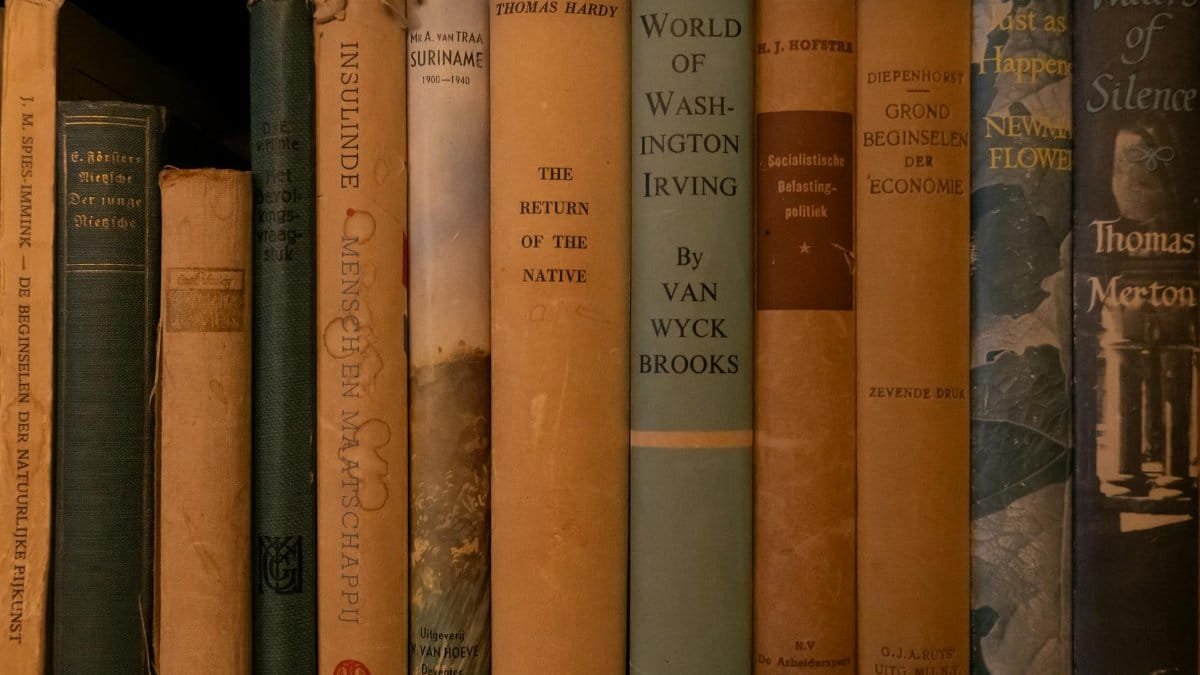 A collection of vintage books arranged on a shelf showcasing their spines.