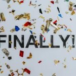 Colorful confetti scattered over the word 'Finally' symbolizing celebration or achievement.