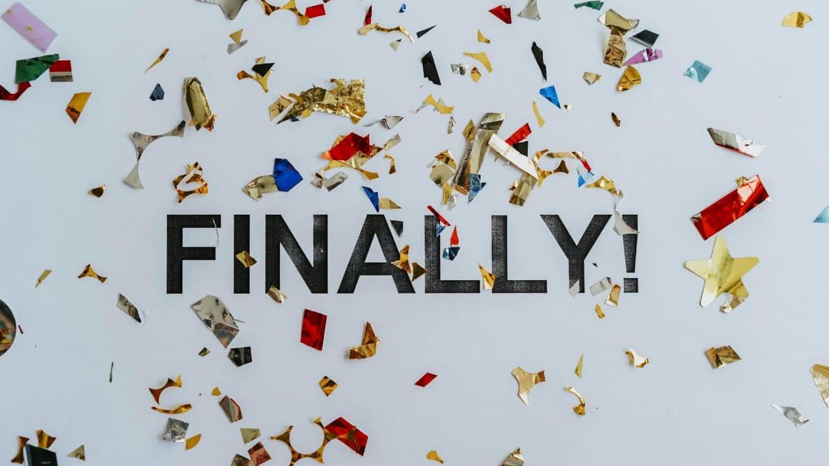 Colorful confetti scattered over the word 'Finally' symbolizing celebration or achievement.