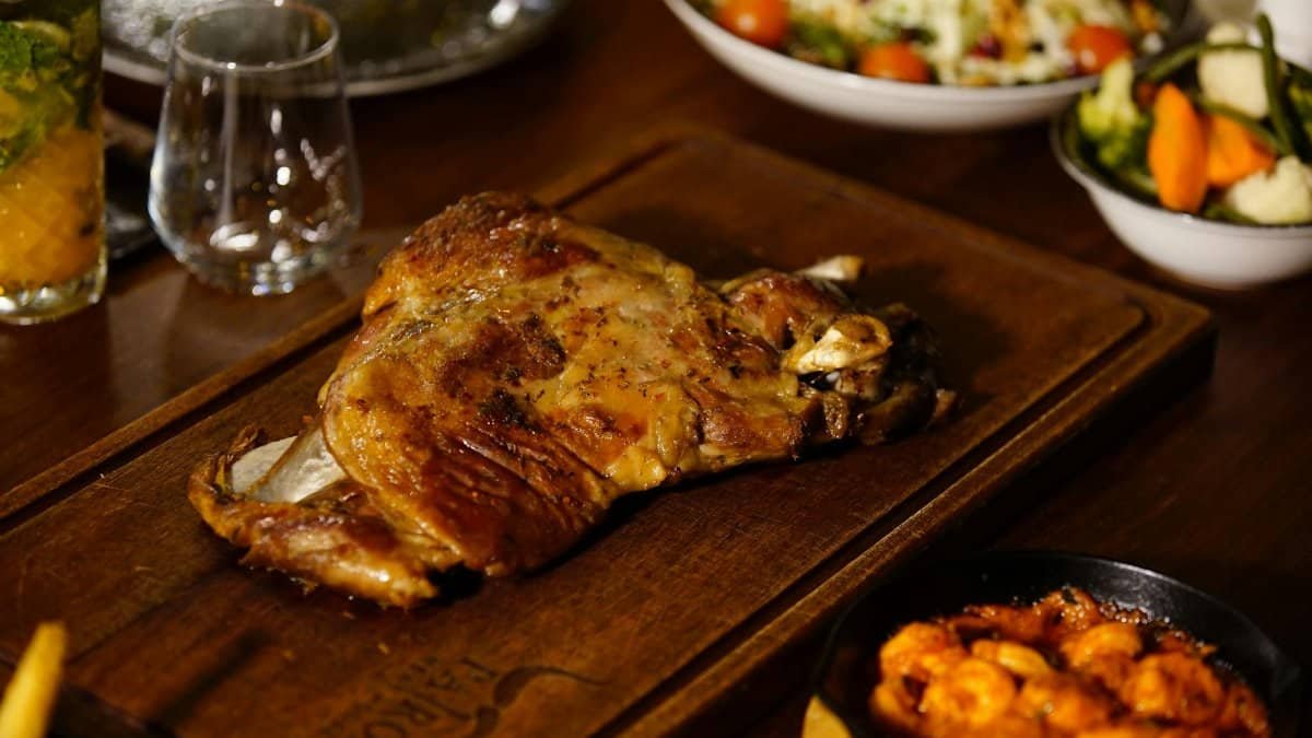 A mouthwatering grilled lamb dish served with vegetables and sauces, perfect for a gourmet feast.