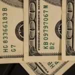 Detailed close-up shot of US dollar bills displaying serial numbers and Federal Reserve details.