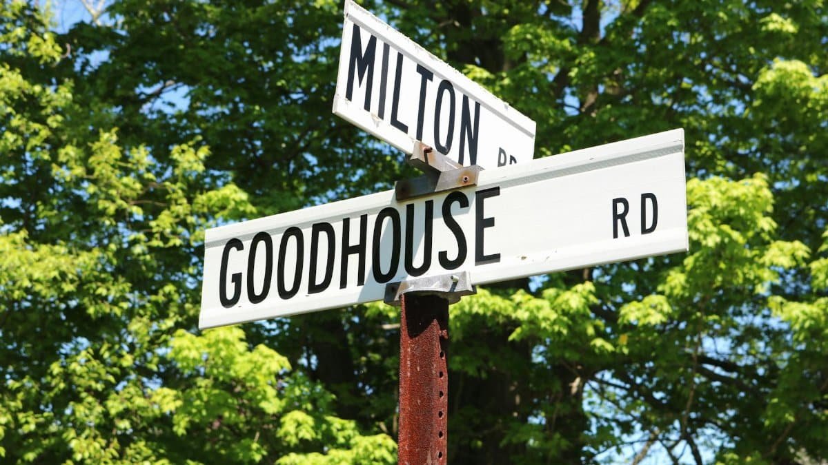 Street signs for Milton Rd and Goodhouse Rd with trees in the background.