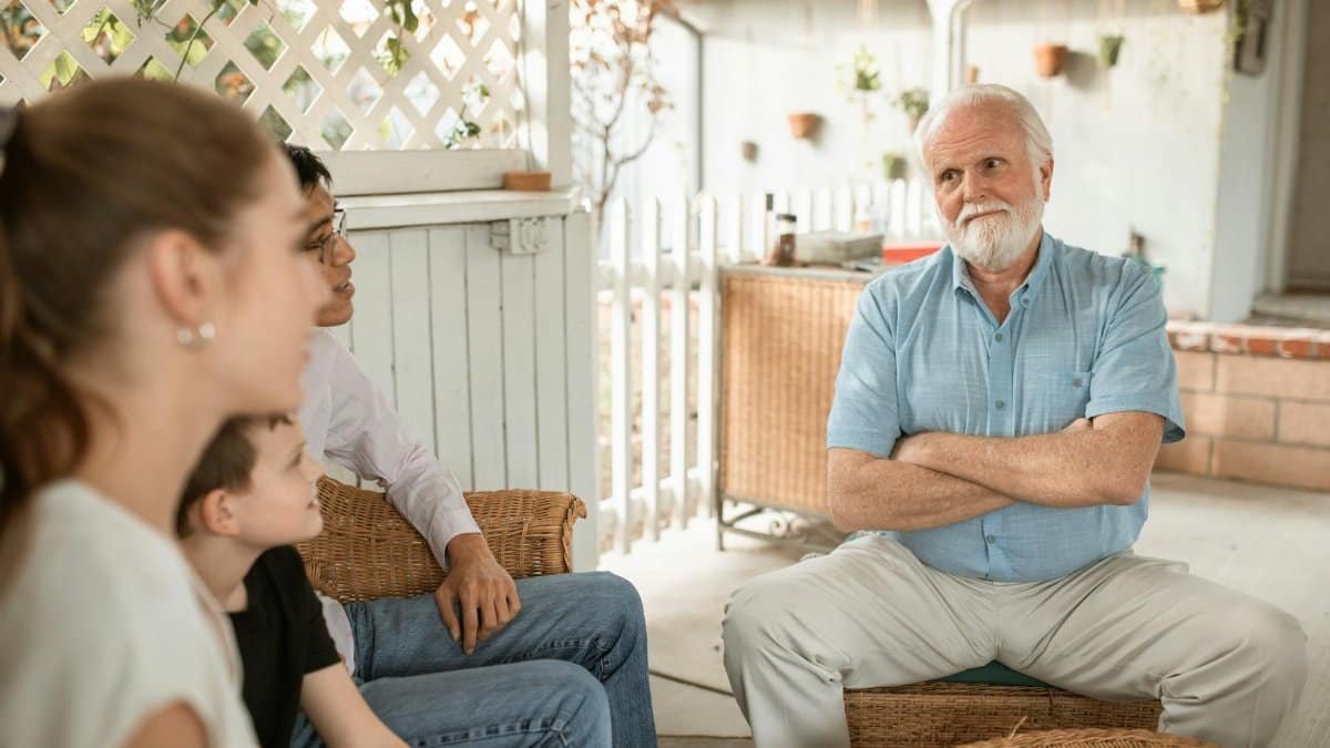 Family gathered indoors, engaged in conversation with a focus on bonds and togetherness.