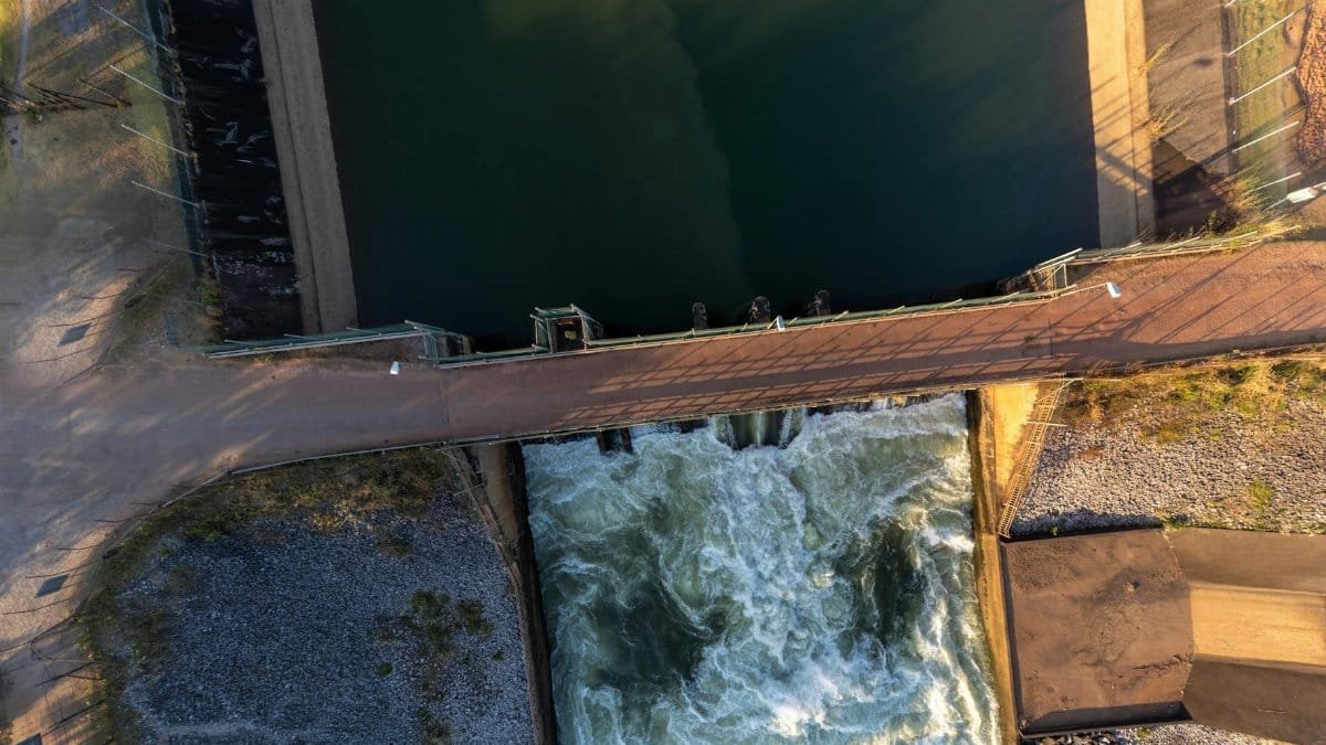 Aerial shot of a hydroelectric dam in Laos, capturing water flow and infrastructure.