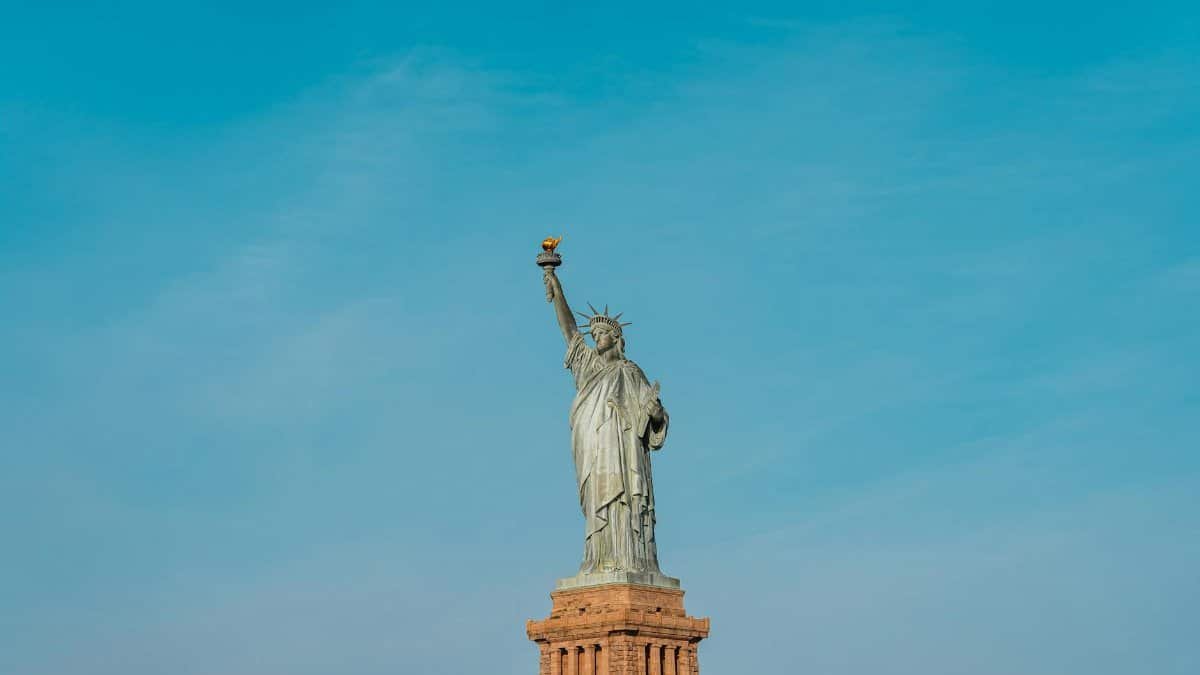 Iconic view of the Statue of Liberty against a clear blue sky in New York City.