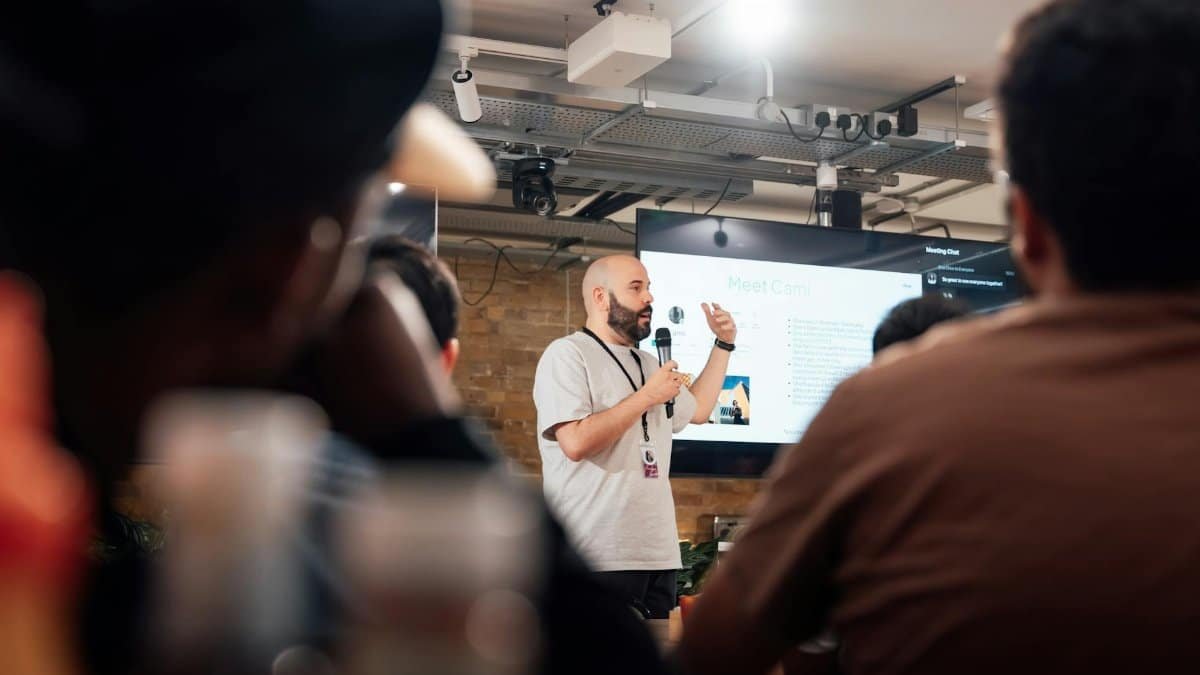 Engaging speaker presenting to an attentive audience during a tech event in London.