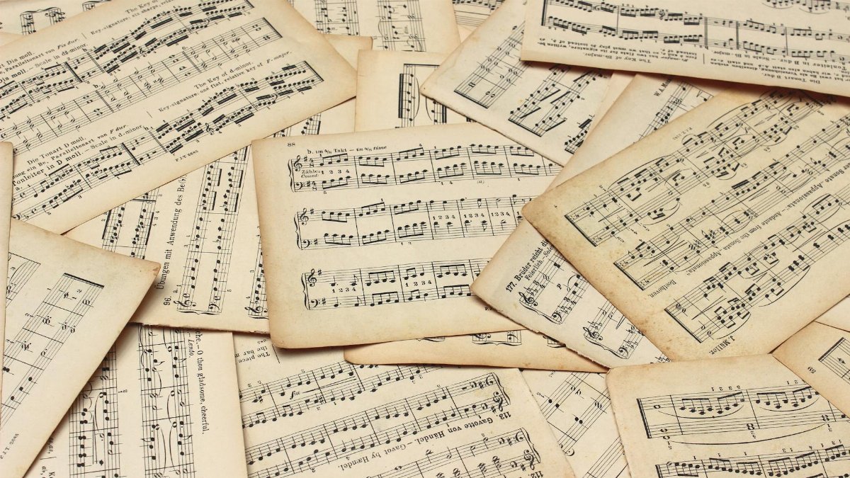 A collection of vintage music sheets scattered artistically, showcasing classic musical notation.