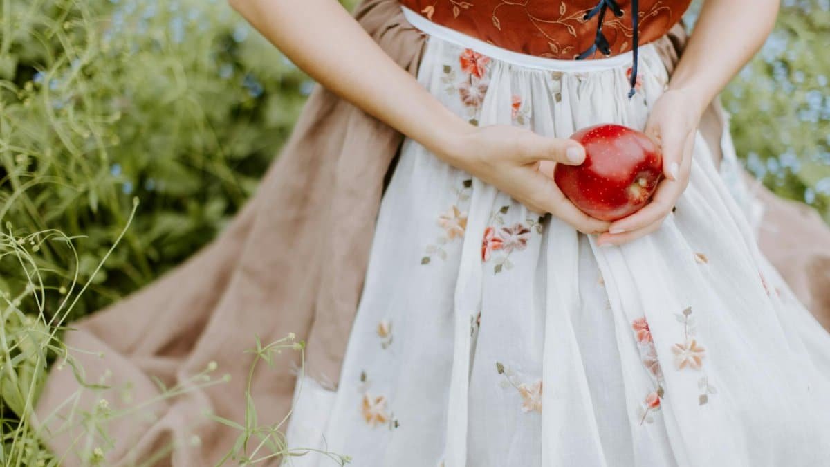Elegant portrayal of a woman holding an apple, inspired by fairy tales.