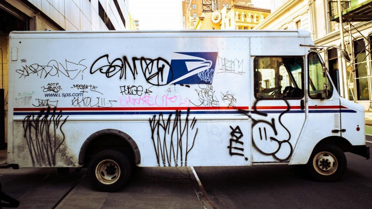 Graffiti-covered delivery truck parked in New York City street, showcasing urban art culture.