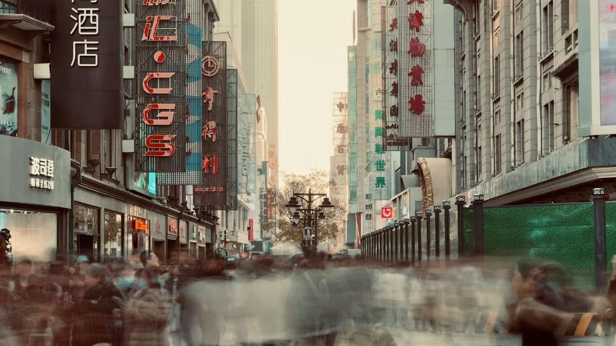 Blurred crowd on a busy Tianjin street with colorful signs and busy atmosphere.