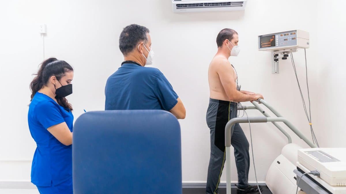 Patient undergoing a cardiac stress test in a medical clinic with a healthcare team.