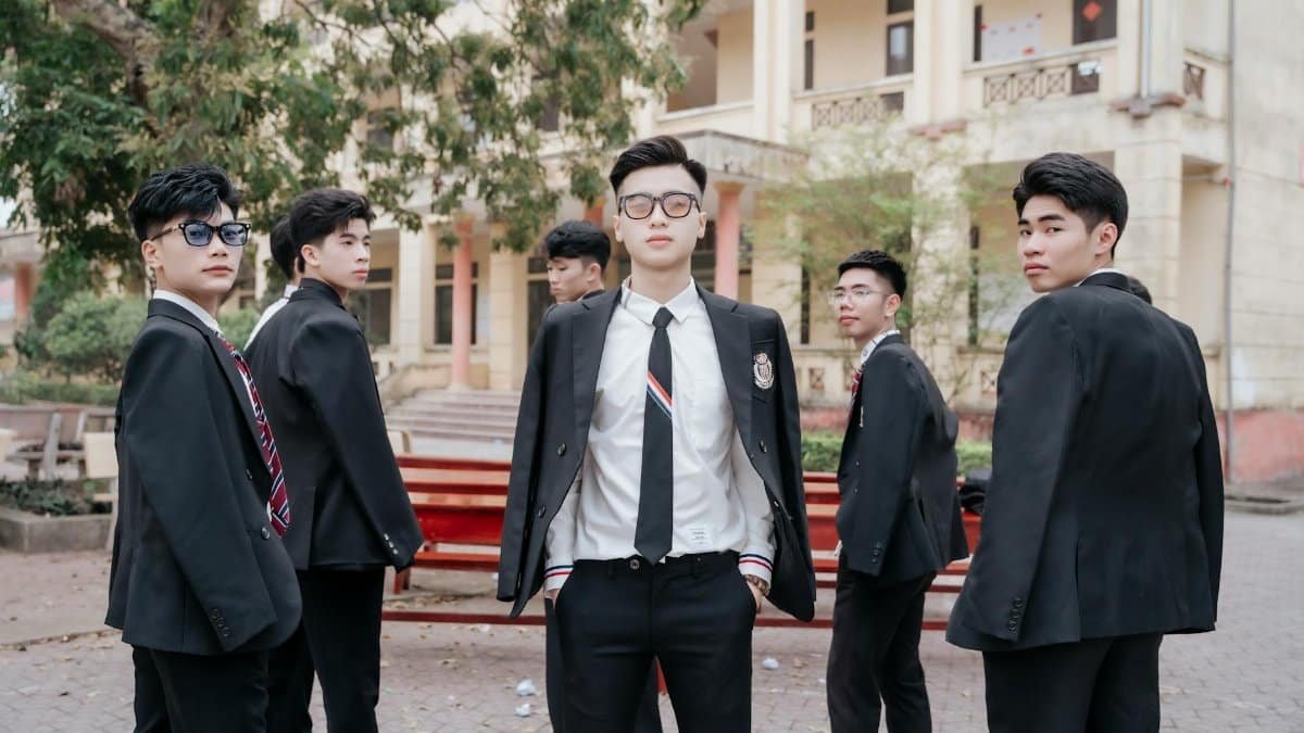 Six young men in suits standing confidently outside a building. Professional and stylish vibe.