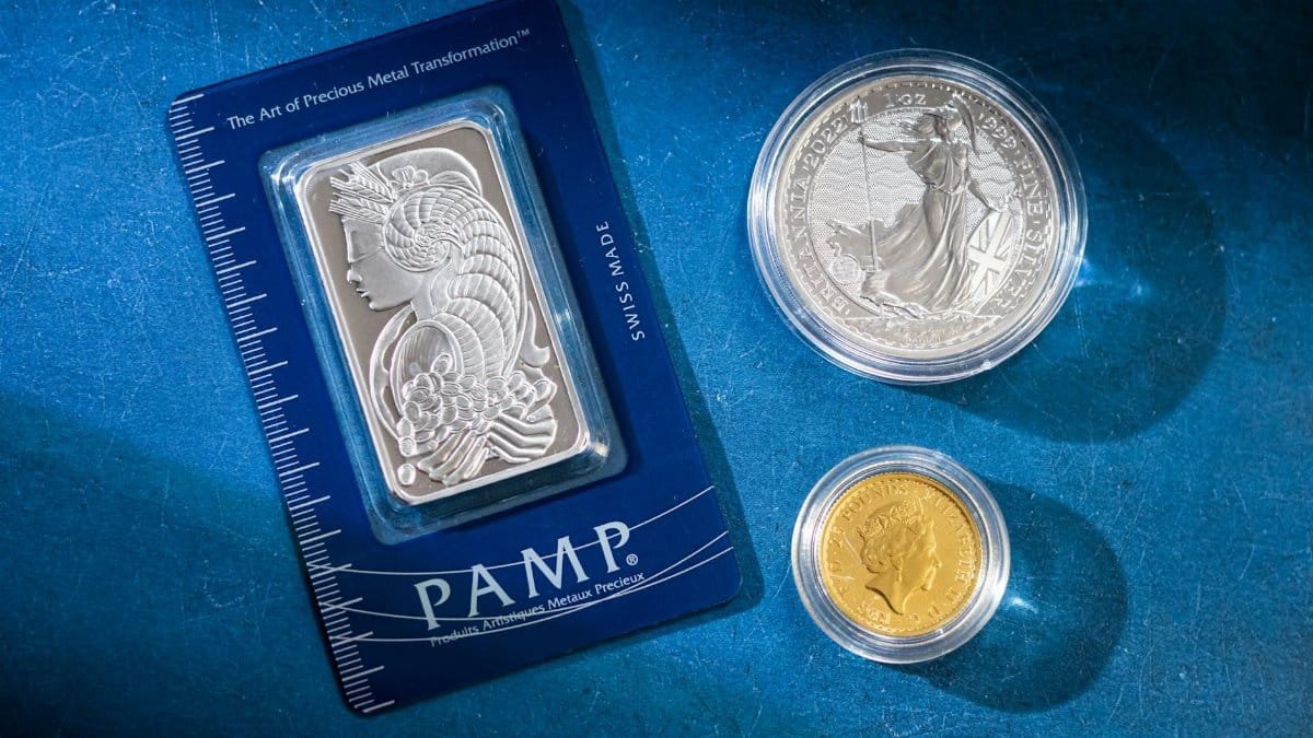 Silver bar and coins on blue surface, highlighting investment and collectible value.