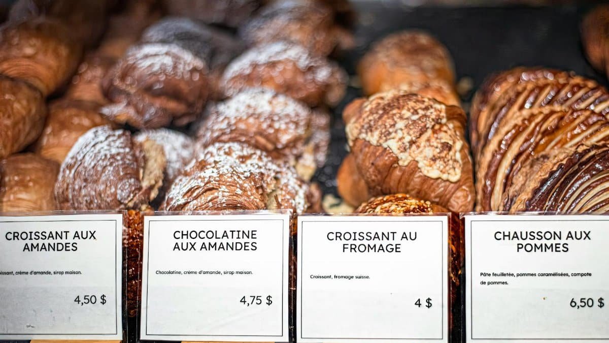 Delicious French pastries displayed with price tags at a bakery counter.