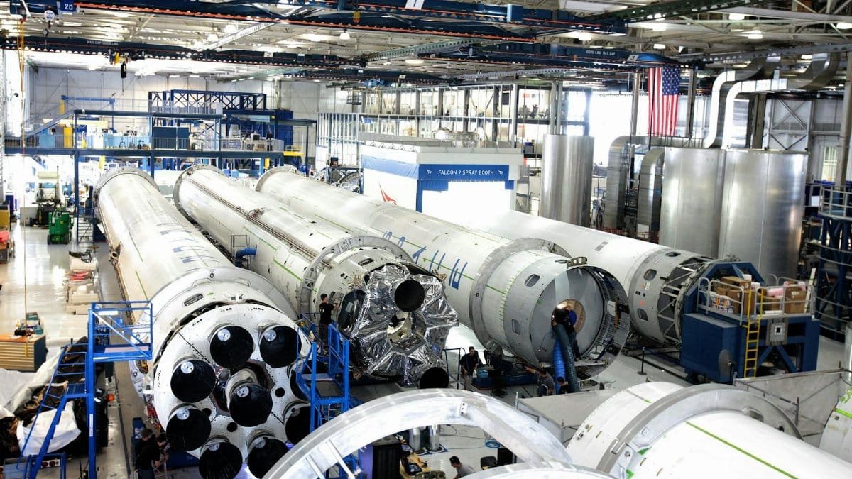 View of a spacecraft assembly line with rockets in a spacious hangar.