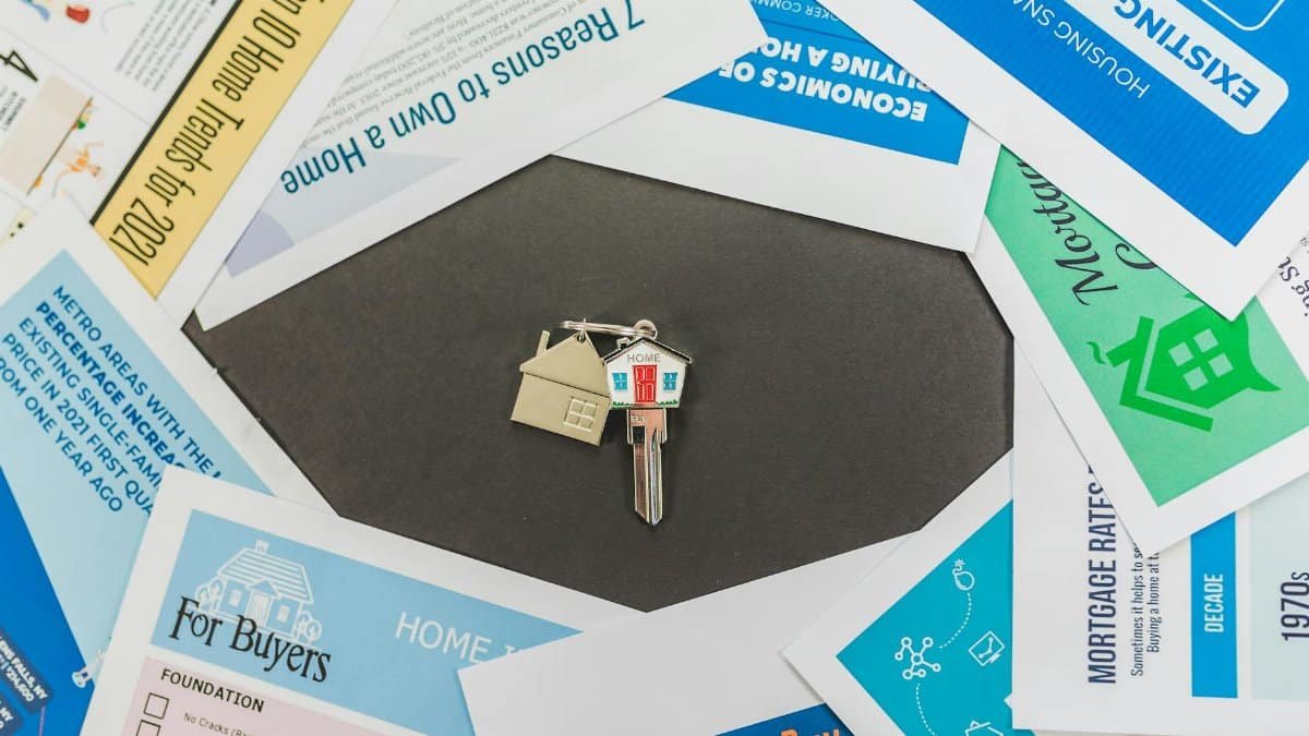 Overhead view of real estate brochures and house key, ideal for marketing.