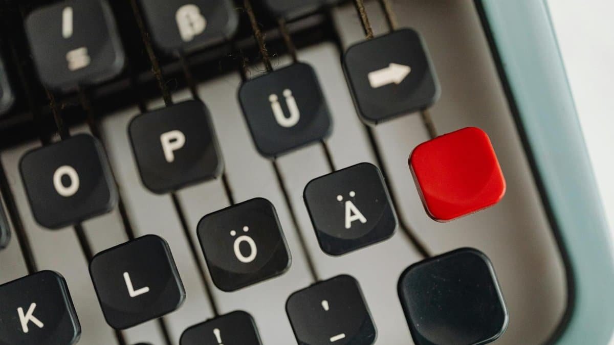 Detailed close-up of vintage typewriter keys with unique characters and a distinct red key.