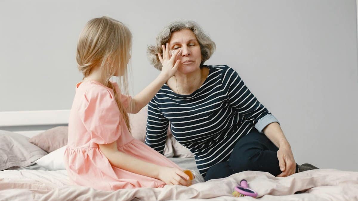 A touching moment of a grandmother and granddaughter bonding on a bed, highlighting family love.
