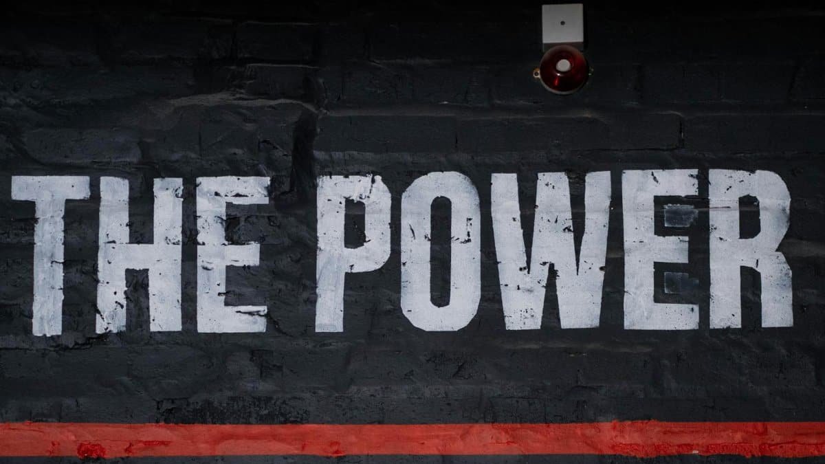 Close-up of 'The Power' graffiti on a dark wall, emphasizing strength and impact.