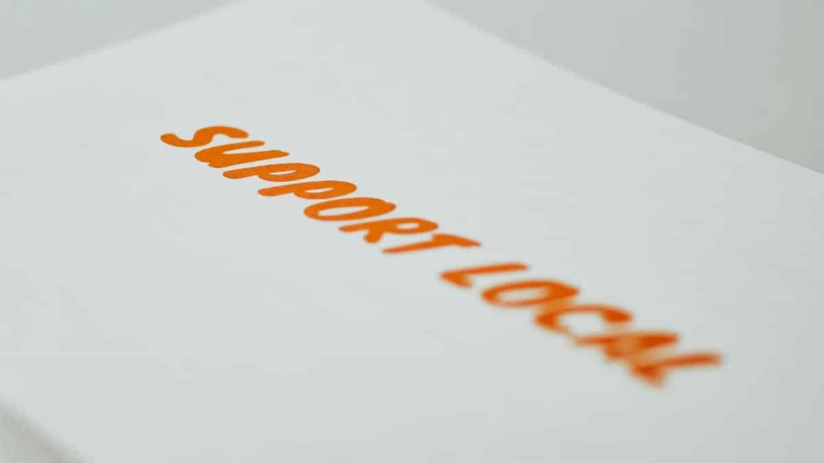 Close-up of a 'Support Local' slogan on a paper, promoting community-driven initiatives.