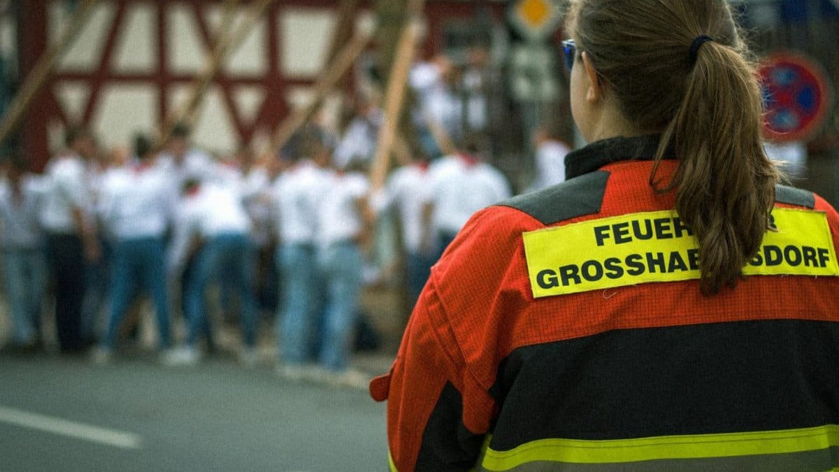 A firefighter in uniform observes a local event, reflecting safety and duty in Großhabersdorf.
