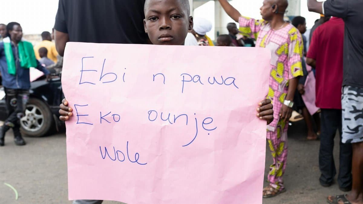 A young boy participates in a street protest in Oshun, Nigeria, highlighting local issues.