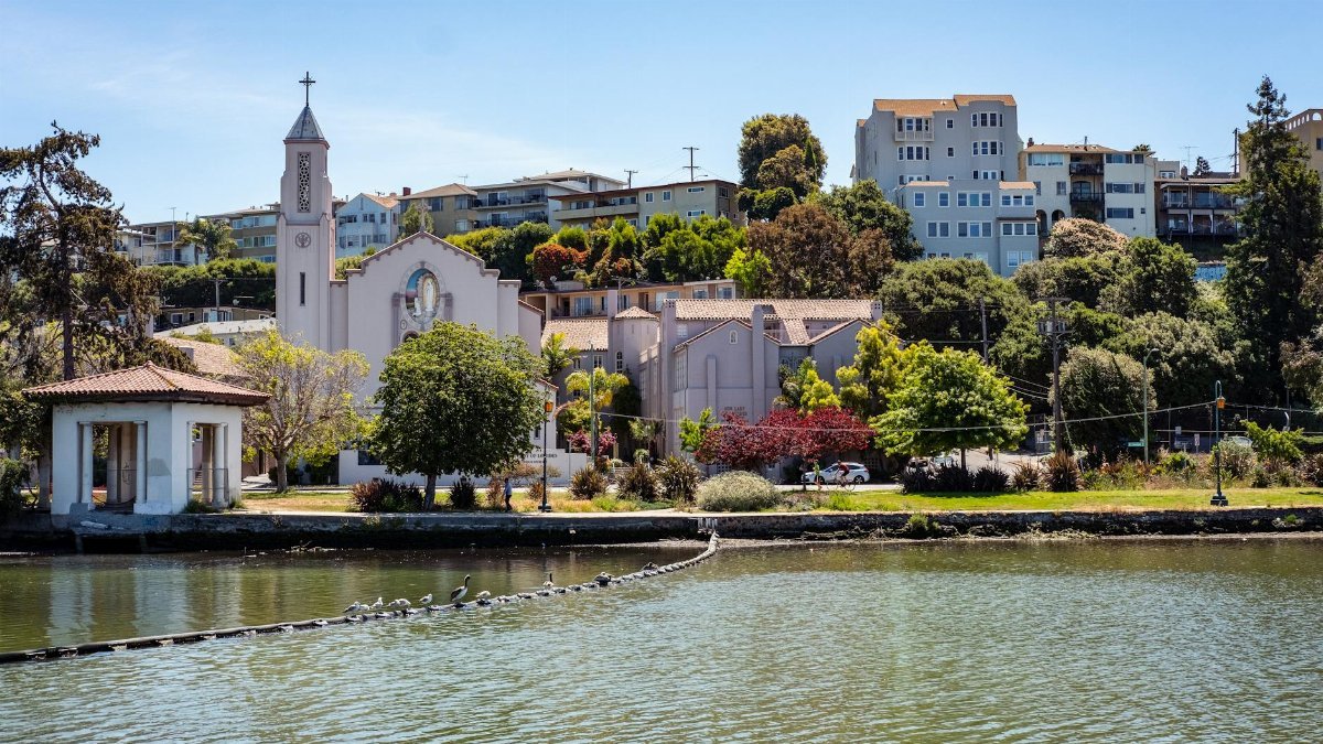 Beautiful view of Our Lady of Lourdes Church and surrounding buildings by the waterfront in Oakland, California.