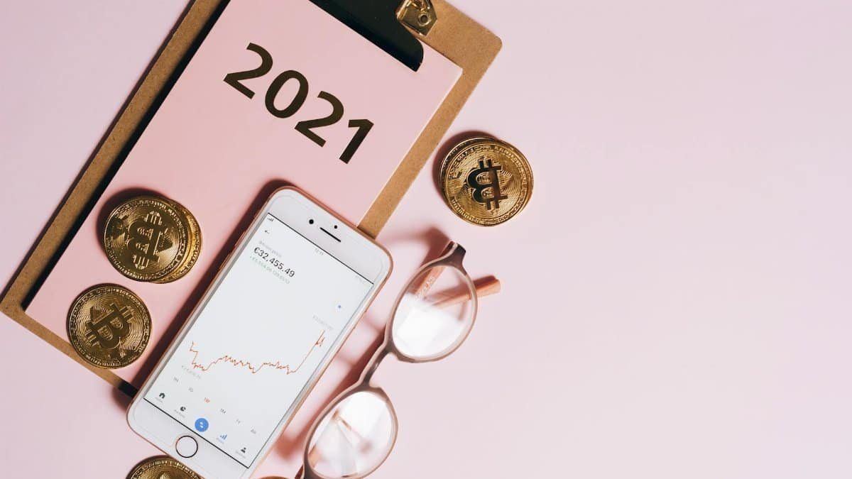 Visual representation of cryptocurrency trends with coins, smartphone, and financial charts on a clipboard.