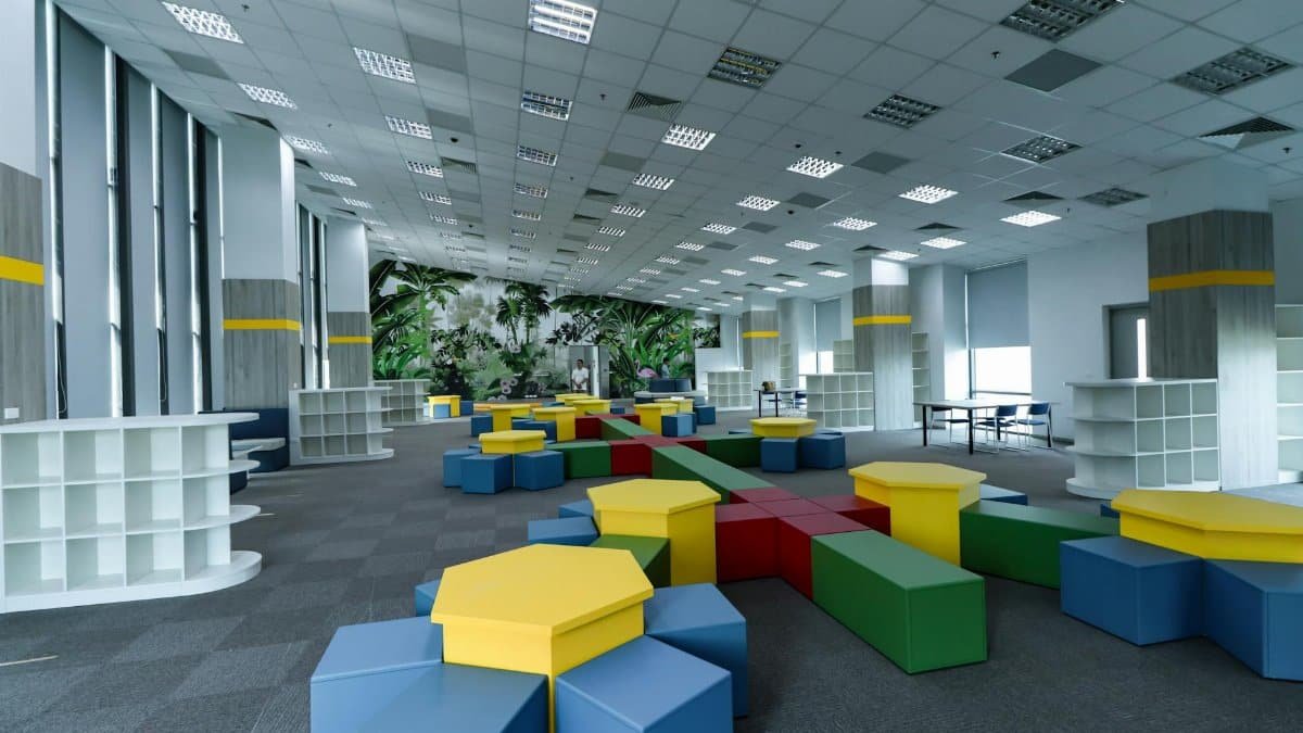 Spacious modern indoor learning space with colorful furniture and tropical theme decor.