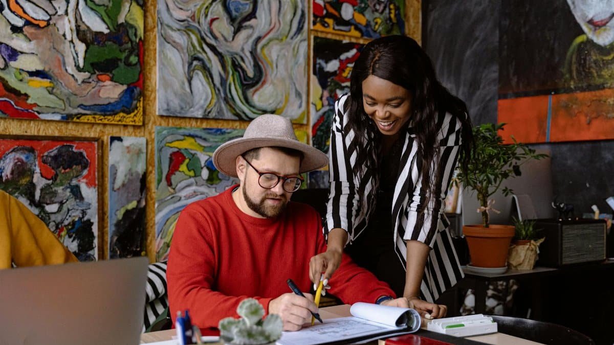 A diverse team working together on an art project in a creative office environment.