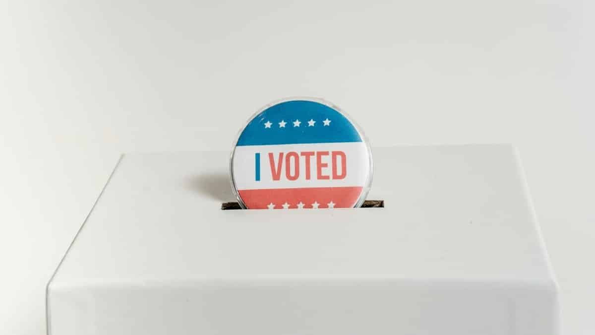 Close-up of an I Voted badge on a ballot box, symbolizing voting in the USA elections.