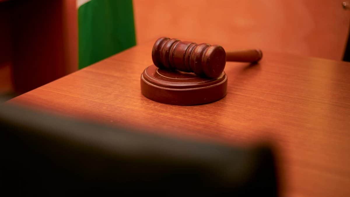 A close-up of a gavel on a courtroom desk representing law and justice.