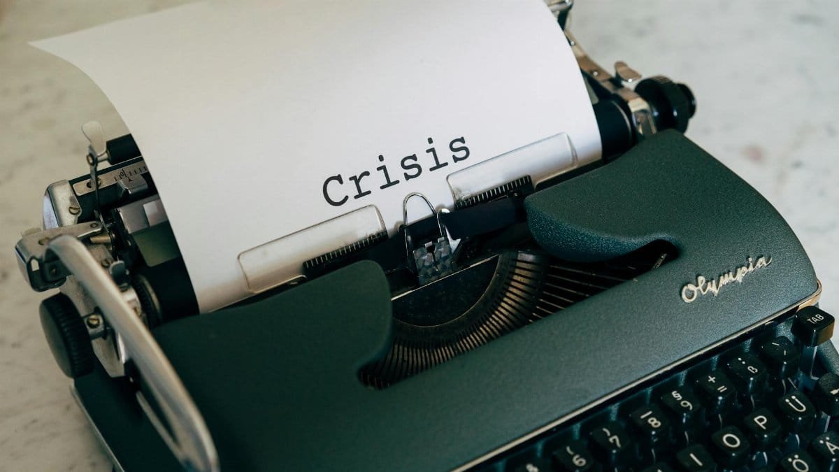 Close-up of a vintage typewriter with the word 'Crisis' typed on paper.